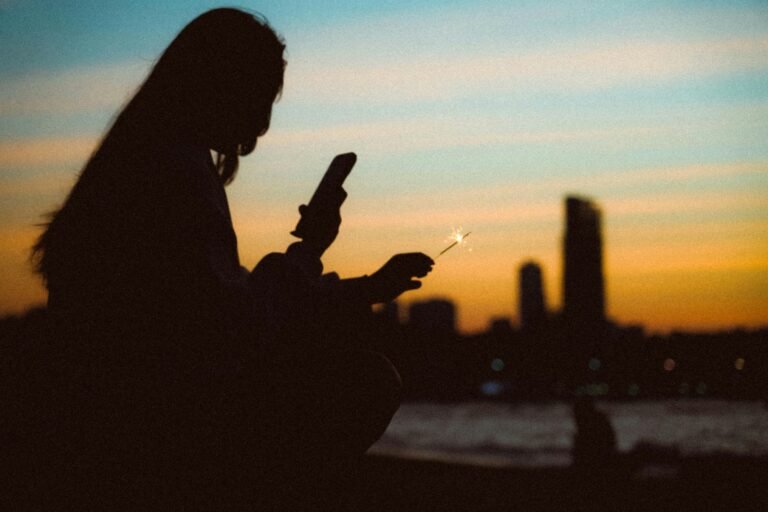 free-photo-of-silhouette-of-a-woman-holding-a-phone-and-a-sparkler